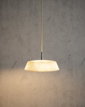Robin Lamps Bonn alabaster pendant lit against a concrete wall